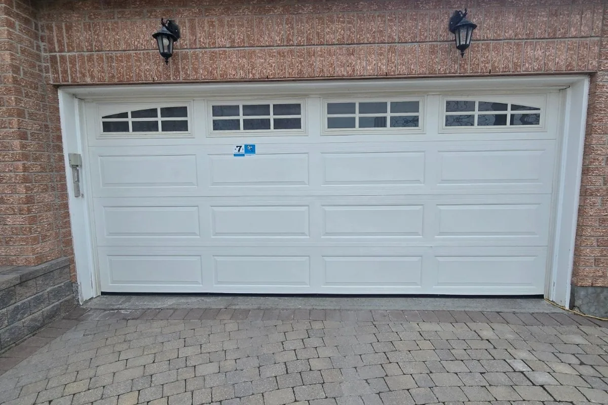 Established Crystal Beach home with a white raised-panel garage door and brick facade
